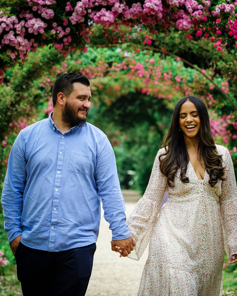 Couple strolling toward the camera along a garden path