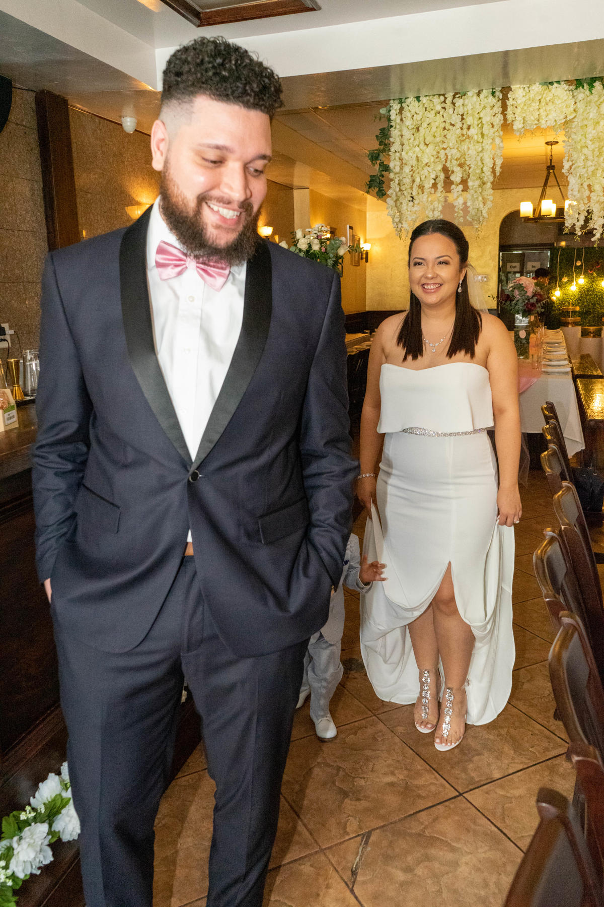 Bride and groom making their entrance into the reception under a floral arch