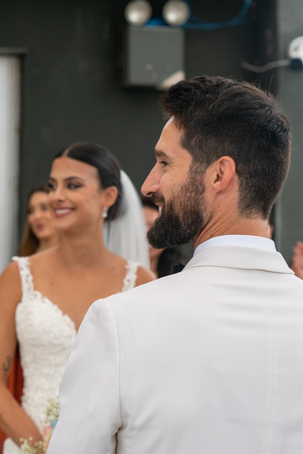 Groom looking over his shoulder at his bride during the ceremony